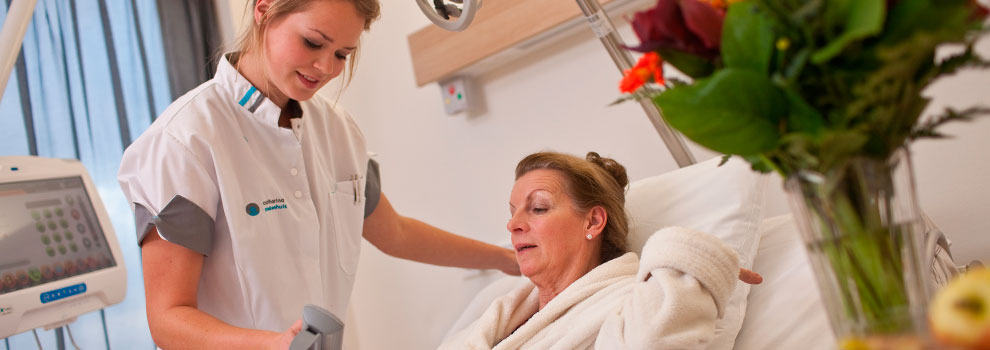 Verpleegkundige aan het bed bij een patiënt