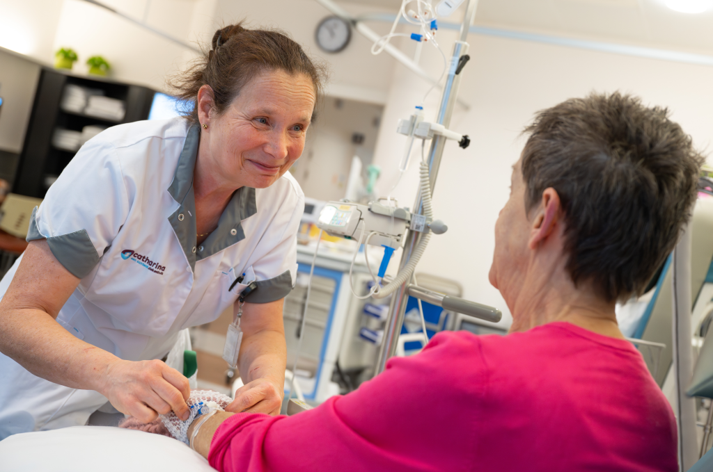 Verpleegkundige Irma Seuter helpt een patiënte. Foto: Guy van Dael/Catharina Ziekenhuis